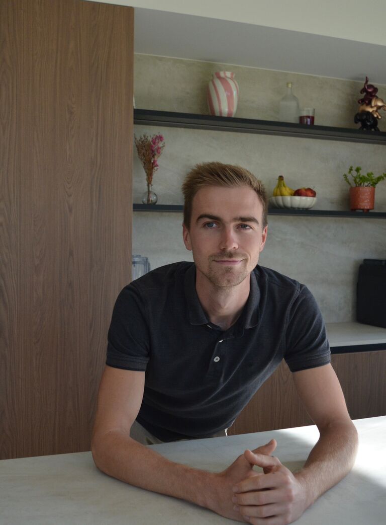 Jonas Herbiest, oprichter van Dhumas, leunend op een werkblad in een moderne keuken